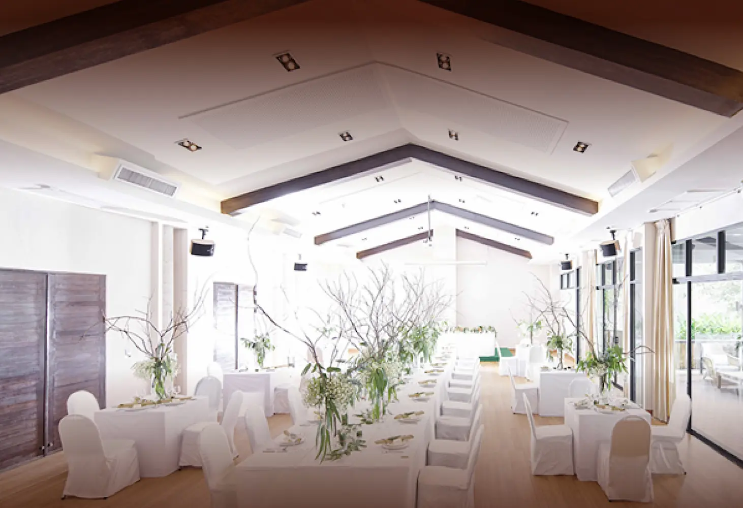 Bright and airy hotel room with two beds overlooking a lush garden.